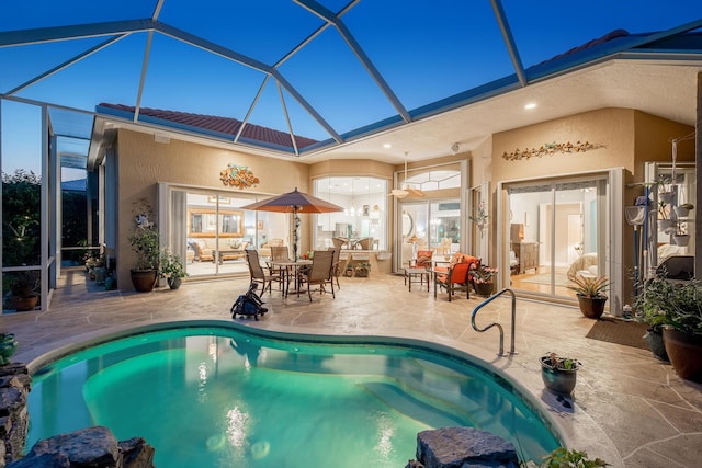 outdoor pool with glass enclosure and a patio area