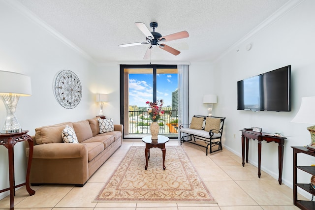 living room featuring light tile patterned floors, a textured ceiling, a ceiling fan, baseboards, and ornamental molding