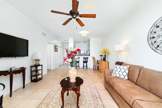 living room with light tile patterned floors, ceiling fan, and ornamental molding