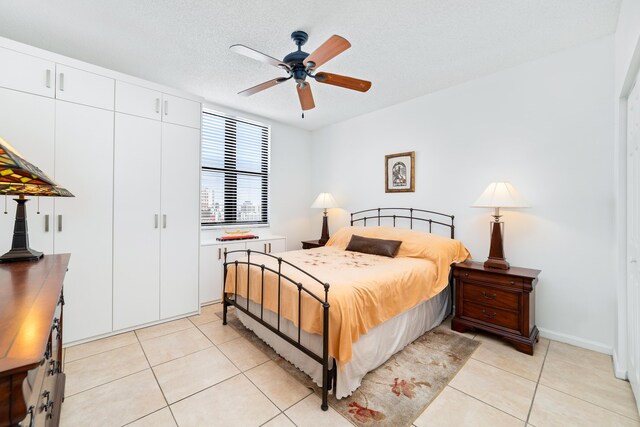 bedroom with light tile patterned floors, a textured ceiling, and a ceiling fan