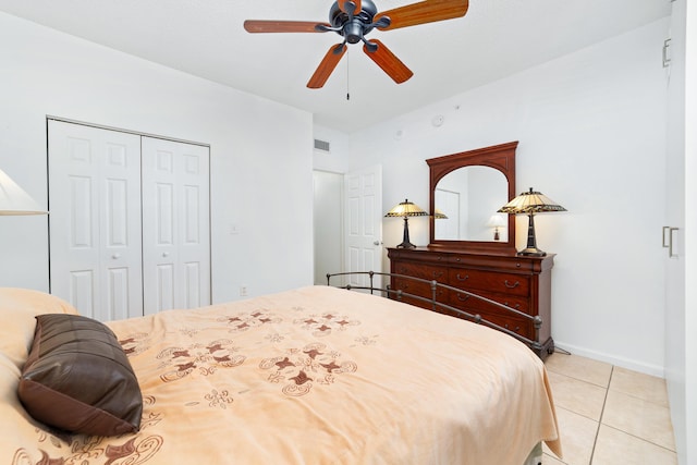 bedroom with a closet, visible vents, a ceiling fan, light tile patterned flooring, and baseboards