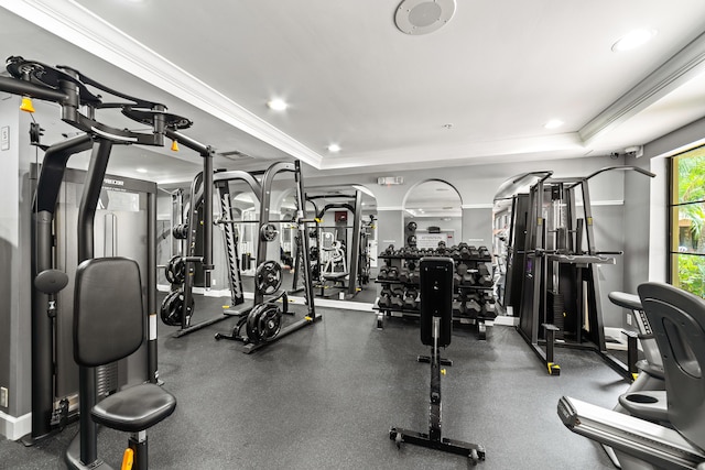 workout area with a tray ceiling, crown molding, and recessed lighting