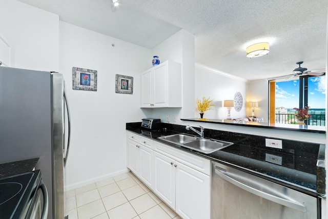 kitchen featuring appliances with stainless steel finishes, white cabinets, a sink, and a ceiling fan