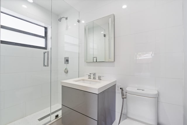 full bathroom with tile walls, tasteful backsplash, toilet, a shower stall, and vanity