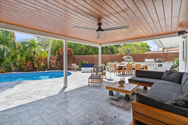 view of patio / terrace featuring exterior kitchen, a fenced backyard, an outdoor living space, and a fenced in pool