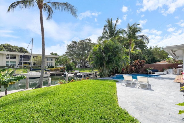 view of yard featuring a fenced in pool, a patio, a water view, a boat dock, and fence