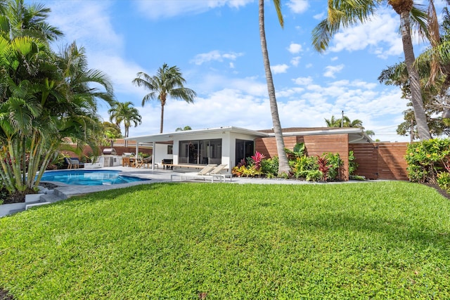 back of house featuring a fenced in pool, a yard, a patio, a sunroom, and fence