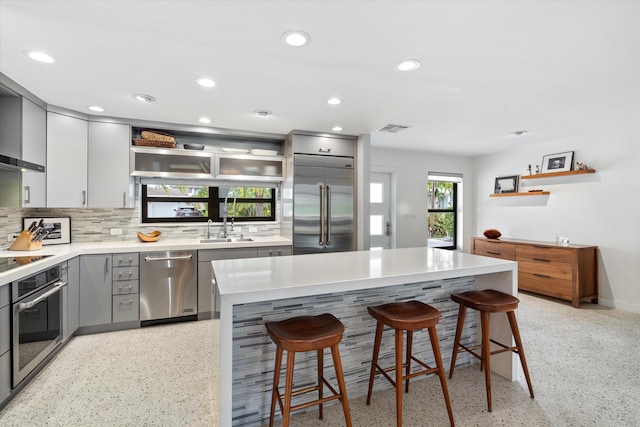 kitchen featuring light speckled floor, visible vents, gray cabinetry, appliances with stainless steel finishes, and a sink