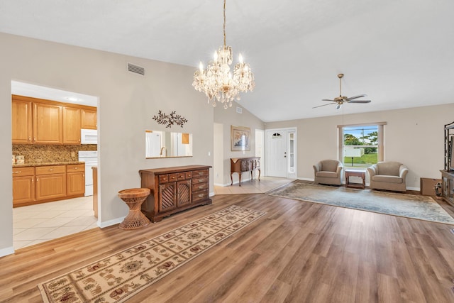 living area featuring visible vents, baseboards, light wood-style flooring, ceiling fan, and high vaulted ceiling