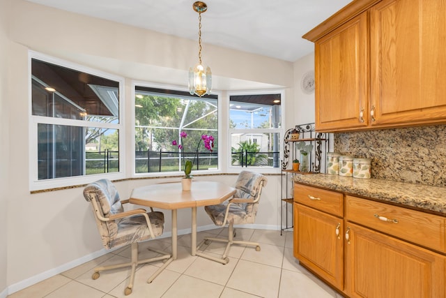 dining room with light tile patterned floors, baseboards, and breakfast area