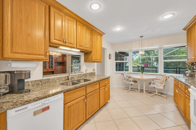 kitchen featuring light stone counters, stove, a sink, a textured ceiling, and dishwasher