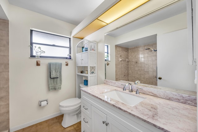 bathroom with baseboards, tiled shower, toilet, tile patterned floors, and vanity