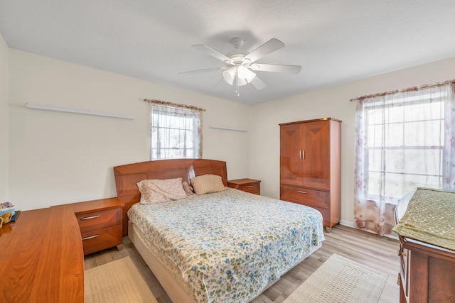 bedroom with light wood-style flooring and a ceiling fan