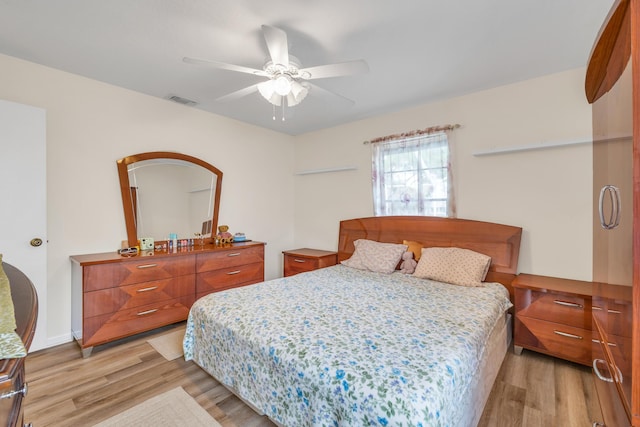 bedroom featuring light wood-style floors, visible vents, and ceiling fan