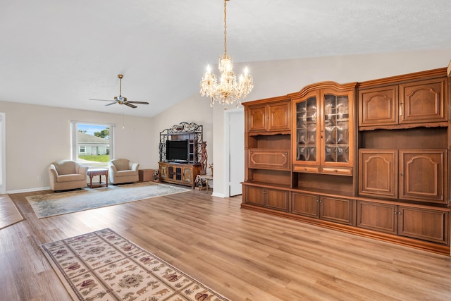 unfurnished living room featuring light wood finished floors, baseboards, vaulted ceiling, and ceiling fan with notable chandelier