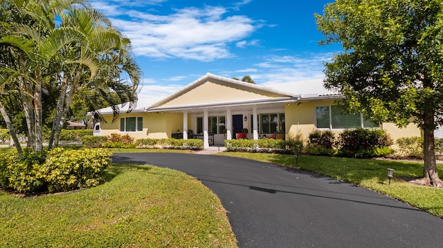 ranch-style home with stucco siding and a front yard