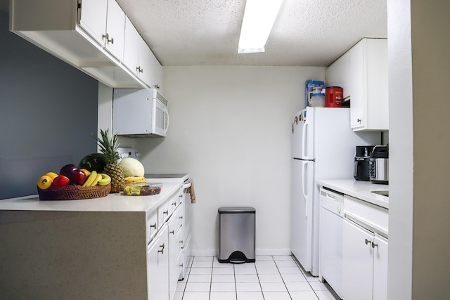 kitchen with white appliances, light tile patterned floors, light countertops, and a textured ceiling