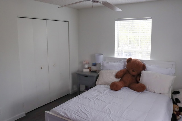 bedroom with a closet, dark wood-style floors, and a ceiling fan