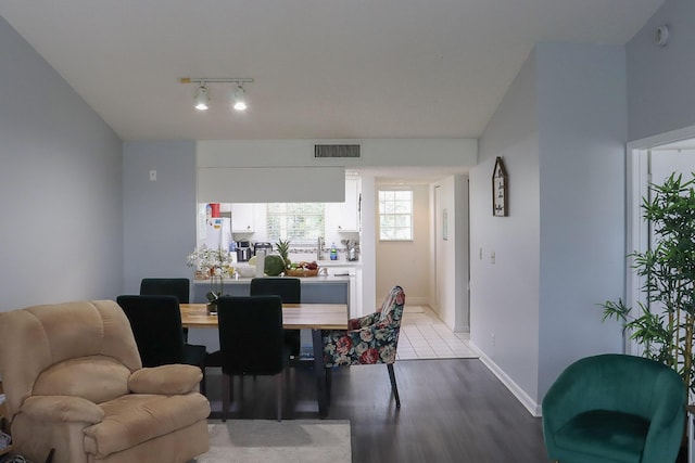 dining room with visible vents, baseboards, rail lighting, and light wood finished floors