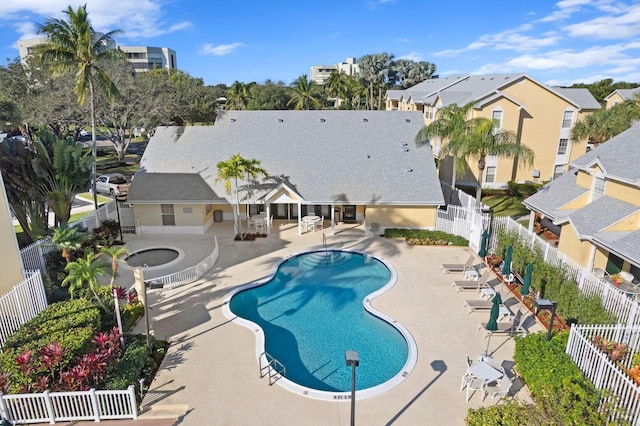 community pool featuring a patio area, a fenced backyard, and a residential view