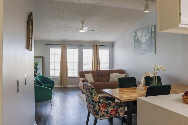 dining area with a textured ceiling, lofted ceiling, ceiling fan, and wood finished floors