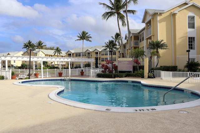 community pool with a patio area, a residential view, a pergola, and fence