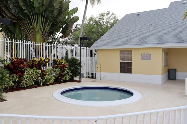 view of swimming pool featuring a patio area, a community hot tub, and fence