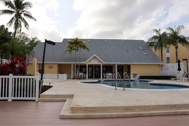 pool with a patio and fence