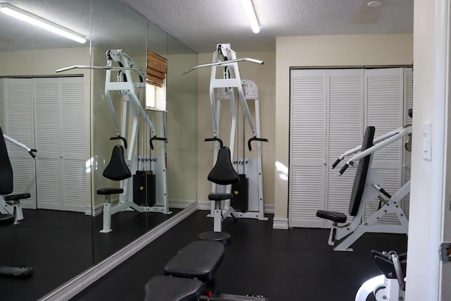 workout area featuring baseboards and a textured ceiling