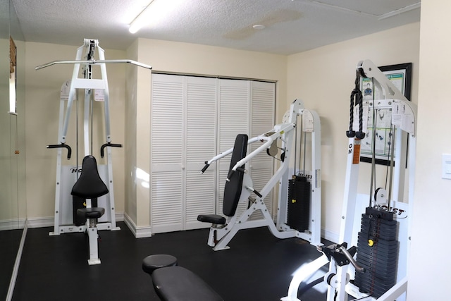 exercise area with baseboards and a textured ceiling