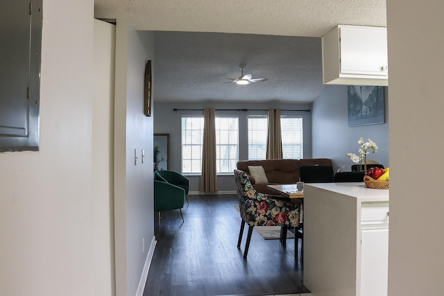 dining area with baseboards, electric panel, dark wood-style flooring, ceiling fan, and a textured ceiling