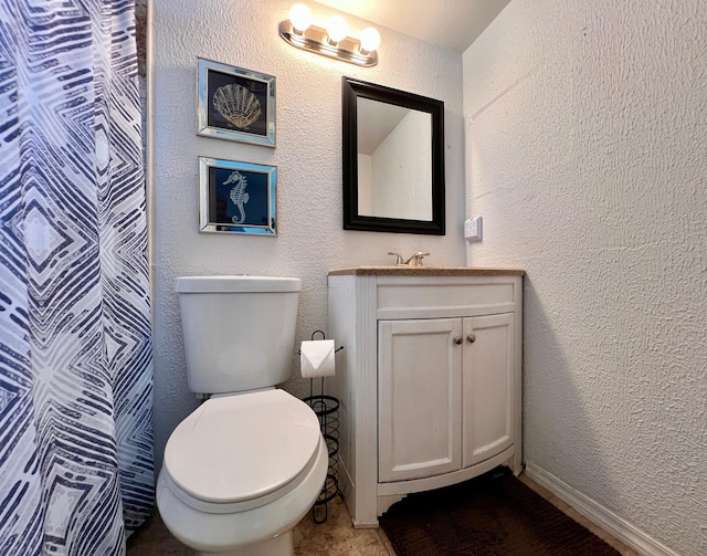 full bathroom with toilet, a shower with curtain, vanity, and a textured wall