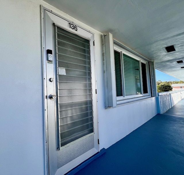 entrance to property featuring stucco siding