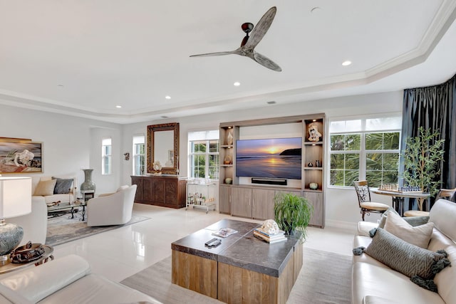 living area with light tile patterned floors, a raised ceiling, ceiling fan, ornamental molding, and recessed lighting