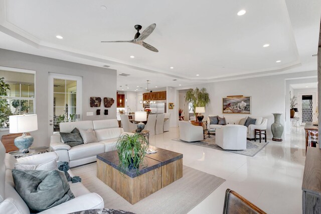 living area featuring recessed lighting, a raised ceiling, and ceiling fan