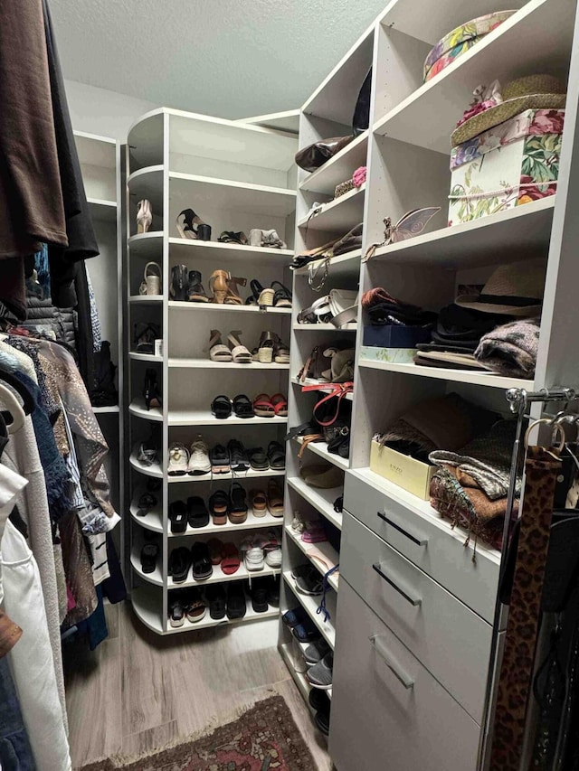 walk in closet with wood finished floors