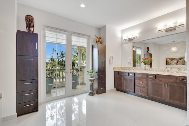 full bath with tile patterned flooring, recessed lighting, baseboards, french doors, and double vanity