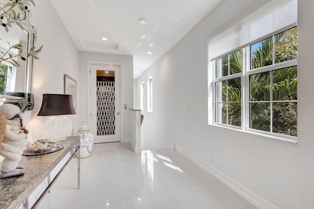 corridor with light tile patterned floors, baseboards, and recessed lighting