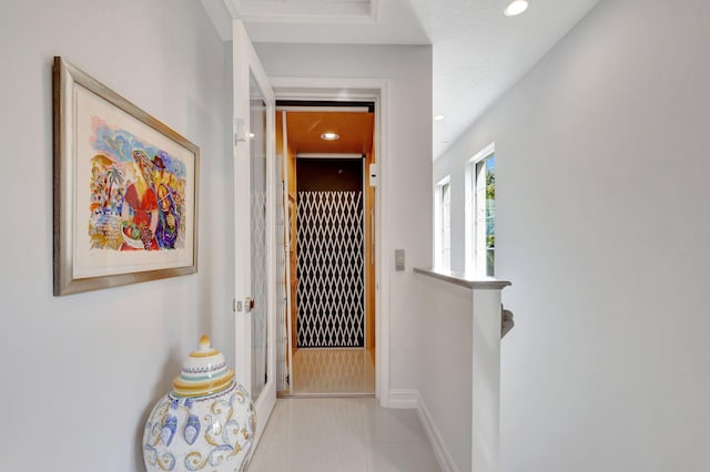 hallway featuring tile patterned flooring, baseboards, and recessed lighting