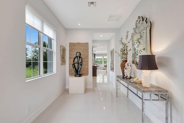 corridor with light tile patterned floors, recessed lighting, visible vents, and baseboards