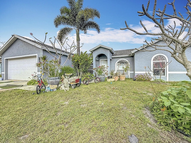 view of front of home featuring an attached garage, concrete driveway, a front yard, and stucco siding