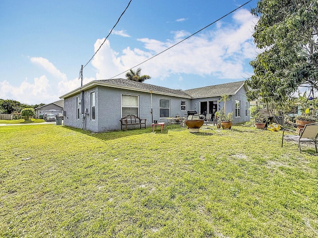 back of property featuring a yard and stucco siding