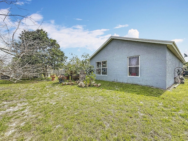 view of property exterior with a lawn and stucco siding