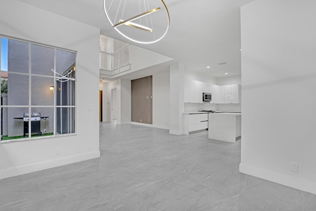 unfurnished living room featuring a chandelier, recessed lighting, and baseboards