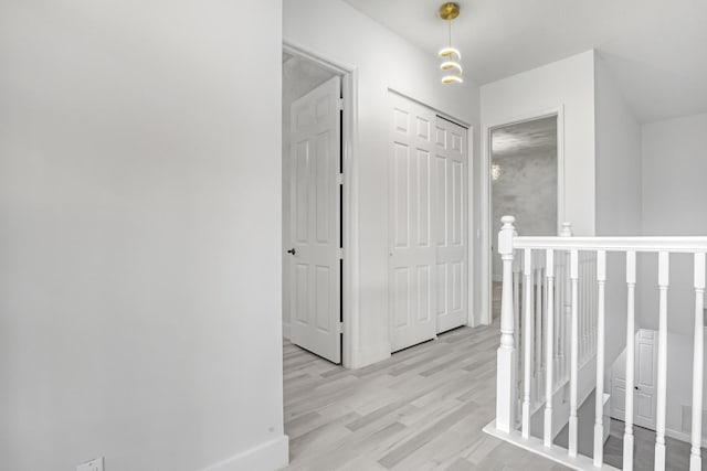 hall featuring light wood-style floors and baseboards