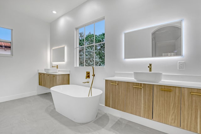 bathroom featuring plenty of natural light, two vanities, and a sink