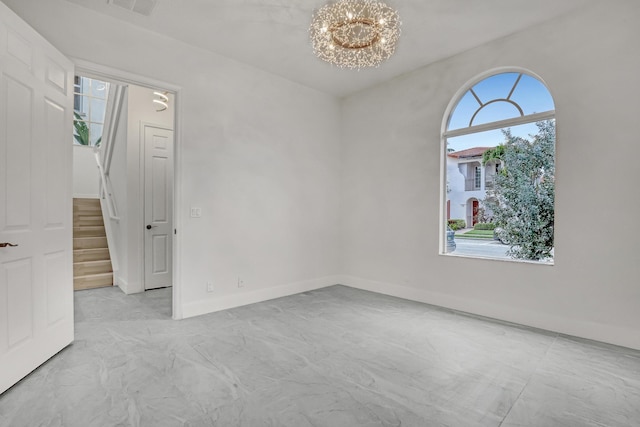 unfurnished room featuring an inviting chandelier, plenty of natural light, stairway, and baseboards