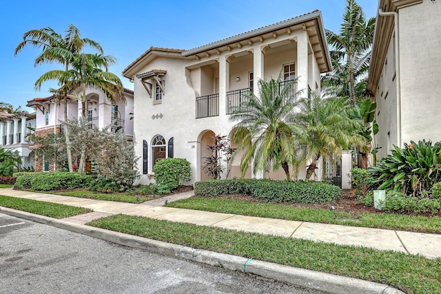 mediterranean / spanish-style house featuring a balcony and stucco siding