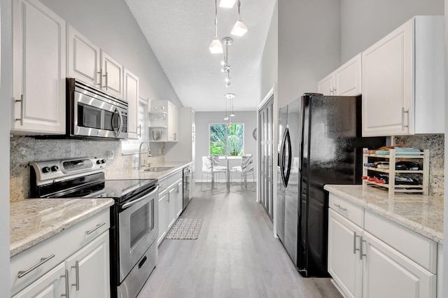 kitchen with white cabinetry, appliances with stainless steel finishes, decorative backsplash, and a sink