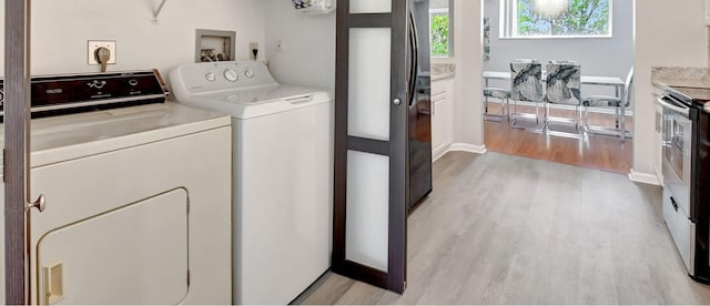 laundry room with light wood finished floors and washing machine and clothes dryer